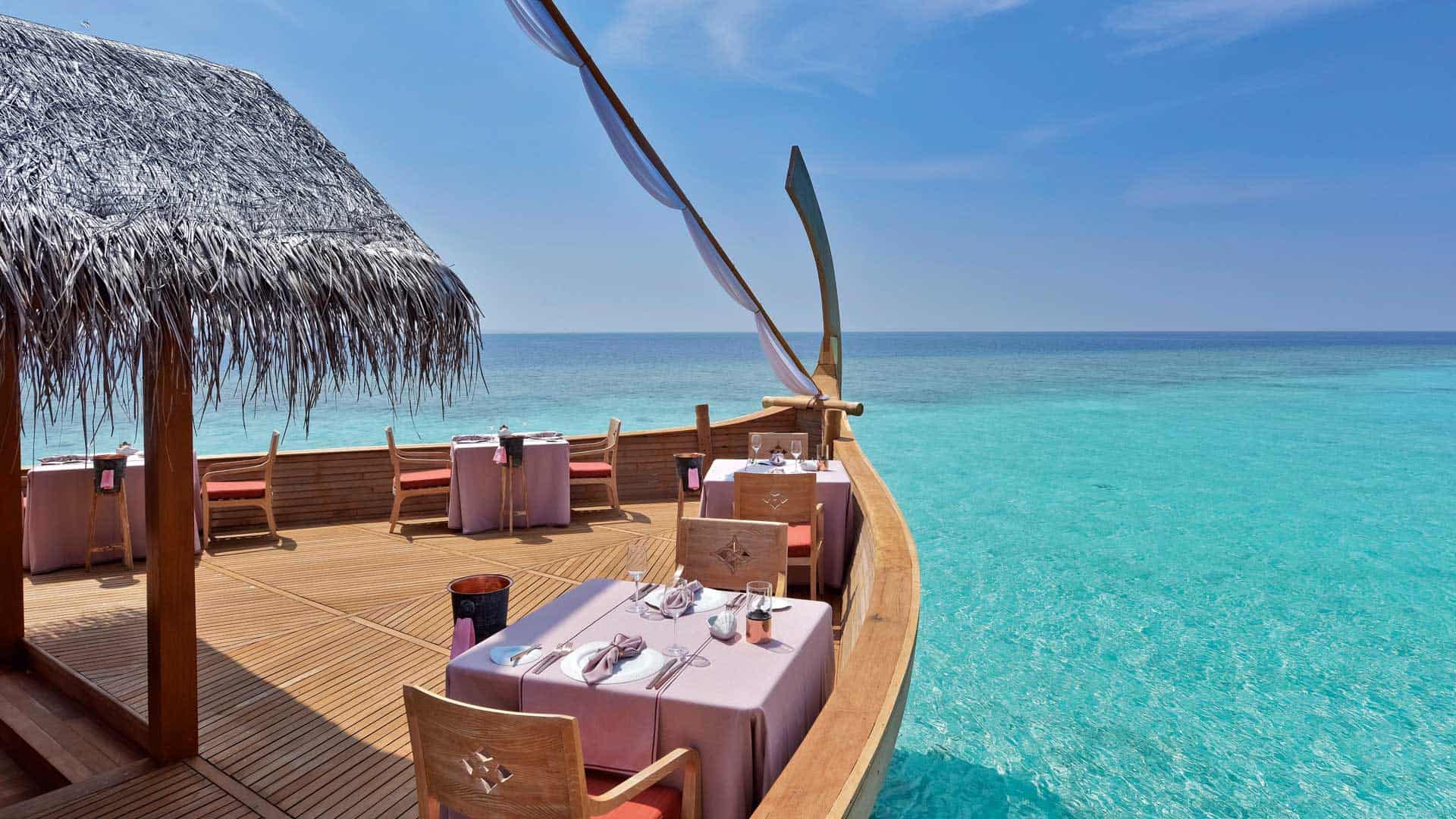 Gedeckte Tische auf einem hölzernen Boot, blaues Meer der Malediven